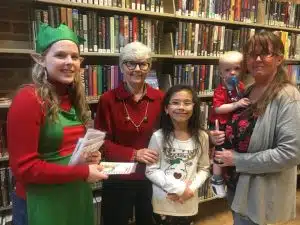 Children receive take home craft from Justin Potter Library during Christmas on the Square