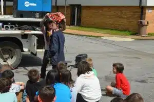 Career Day at DeKalb West School. Welder Brittney Moore helps 5th grade Abram Maynard dress up to prepare for a welding job.