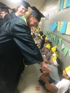 DCHS Seniors Colby Barnes and Ean Jones (behind him) reach out to greet youngsters at Smithville Elementary School during the “Senior Walk” Thursday morning