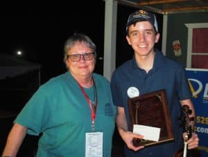For the second year in a row, Noah Goebel of Elkton, Kentucky has claimed the Grand Champion Fiddling Title at the Smithville Fiddlers Jamboree and Crafts Festival. Kim Luton, President and Coordinator of the Fiddlers Jamboree presented the award to Goebel at the conclusion of the festival which ended at 1:30 a.m. Sunday morning, July 2