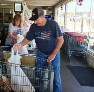 Larry and Deborah Hancock, owners and operators of Larry’s Discount Grocery for 43 years in Smithville, shown here serving a customer Monday morning and preparing for the state’s three-month grocery tax suspension, starting tomorrow, August 1 through October 31.