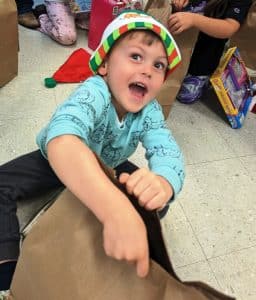 Excited Head Start child tears into his bag of gifts (Shawna Willingham Photo)