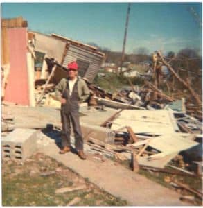 Man standing near debris from the tornado after the storm 50 yeaars ago