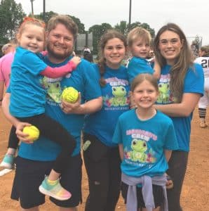 The first pitch of Monday evening’s Region Softball Tournament game between the DCHS Tigerettes and Marshall County in Smithville, was thrown by a young child recently diagnosed with leukemia. Five-year-old Carrigan Cox is the daughter of Brandon and Whitney Cox of Smithville. Accompanied on the field by her parents and siblings, Carrigan’s pitch to the catcher prior to the game was met with rousing cheers and applause from the fans. Members of the Cox family pictured here left to right are: Carrigan, being held by her father Brandon, Cora, Clara, and Callahan being held by mom Whitney. Brandon is DeKalb County’s General Sessions and Juvenile Court Judge