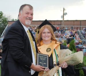 DCHS Principal Bruce Curtis presents White Rose Award to Avery Agee during Class of 2025 Graduation Friday night