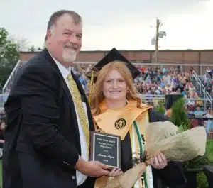 DCHS Principal Bruce Curtis presents White Rose Award to Avery Agee during Class of 2025 Graduation Friday night
