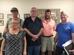 Former Alexandria Mayor and Alderman David Cripps (in dark shirt) was appointed alderman to fill an unexpired term Saturday. He is standing with other Alexandria aldermen pictured left to right: Sherry Tubbs, Bobby Simpson (standing behind her), David Cripps, Luke Prichard, and Jeff Ford. Absent were Mayor Beth Tripp and Alderman Jonathan Tripp