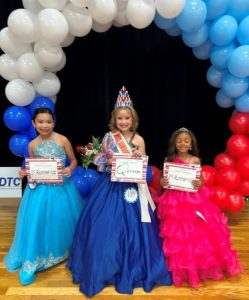 Wrigley Jared (center) was crowned the 2025 Miss Jamboree Queen in the age 7-9 category Saturday. She also took home optional awards for Prettiest Attire and Most Photogenic. Julie Chandyna (left) was 1st runner-up. She also received optional awards for Prettiest Eyes and Prettiest Smile. Brinleigh Cole Bain (right) was 2nd runner-up. She won for Prettiest Hair and the People’s Choice Award.
