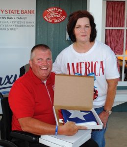 State Representative Michael Hale presented a Tennessee State flag Friday to Becky Givens of Memphis who traveled the longest distance in Tennessee to get here for the Fiddlers Jamboree