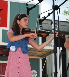 A repeat! A Columbia girl, for the second year in a row, has claimed the top Jamboree award as the best fiddler in the National Championship for Country Musician Beginners. Ella Derby Saturday again won the coveted James G. “Bobo” Driver Memorial Award at the Smithville Fiddlers Jamboree and Crafts Festival